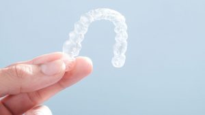 Hand Holding Clear Invisalign Braces